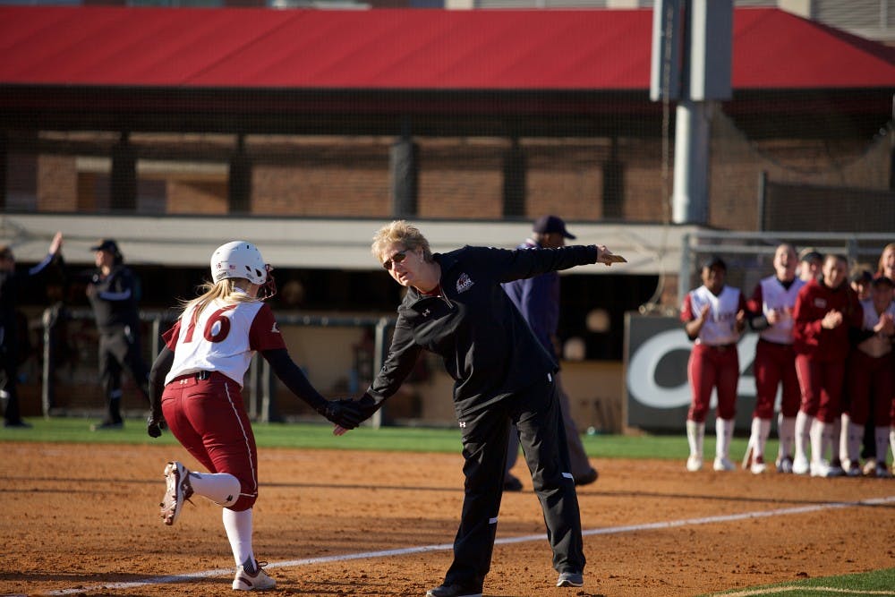 Katrina Martin (#16) high fives softball head coach Kathy Bocock as she runs towards home plate after hitting a home run vs. Charlotte on Feb. 9