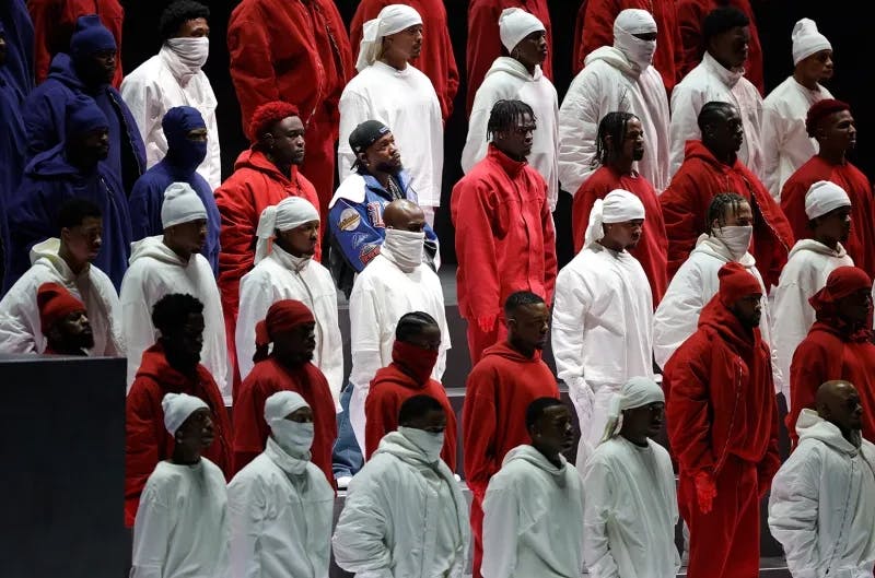 Kendrick Lamar surrounded by backup dancers creating a flag during the Superbowl Halftime Show. -Billboard