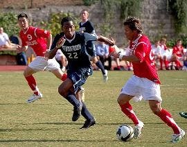 TWO ON ONE - Junior midfielder Luis Martinez (No. 99) looks to dribble around his opponent while senior midfielder Anthony Moy (No. 9) waits to receive the potential pass. 