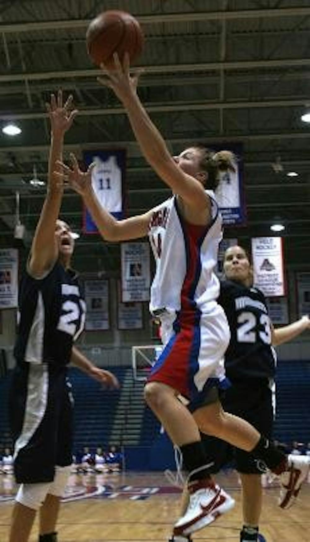 AERIAL ACROBATICS - Senior guard Liz Hayes attempts a shot in the thick of Monmouth University opponents.