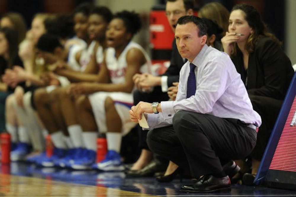 Former women\'s basketball head coach Matt Corkery watches a game from the sidelines.