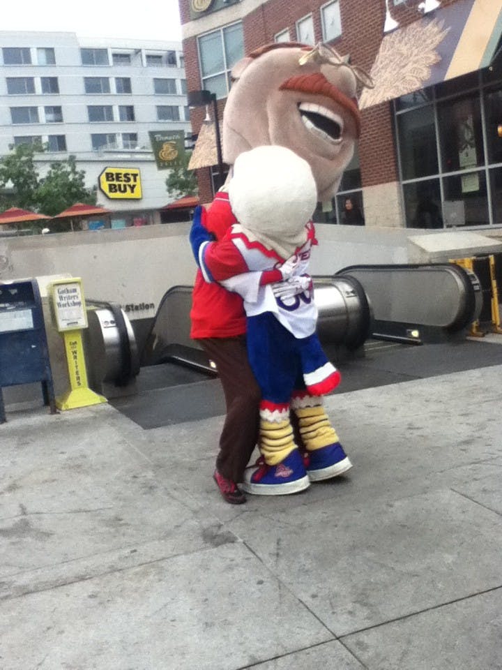 	Nationals’ mascot Teddy Roosevelt and Clawed Z Eagle hug each other after the announcement that AU will help pay for additional metro service for late night post-season games.