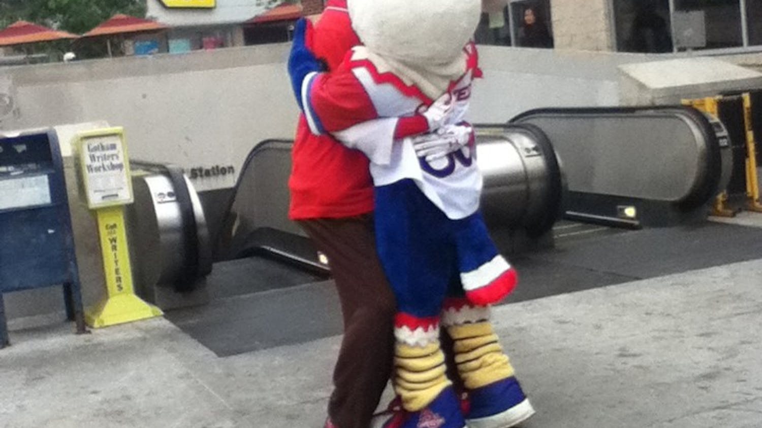 	Nationals&#8217; mascot Teddy Roosevelt and Clawed Z Eagle hug each other after the announcement that AU will help pay for additional metro service for late night post-season games.