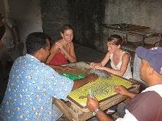 CULTURES CONVERGE - AU students play dominoes with Cuban citizens. A group of AU students are in the country this semester as part of an AU Abroad enclave program. They have incorporated the current political transition into their classes.