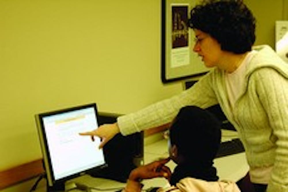 Kirsten Allen teaches Elizabeth Mugo how to use online research tools at Bender library.