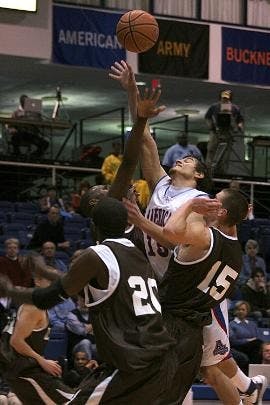 FOLLOW THROUGH- Junior guard Frank Borden drives hard to the basket Sunday against three Lehigh defenders in the Eagles' 82-74 victory (above). Even President Neil Kerwin got into the spirit, practicing his shooting touch in front of thousands of fans at 