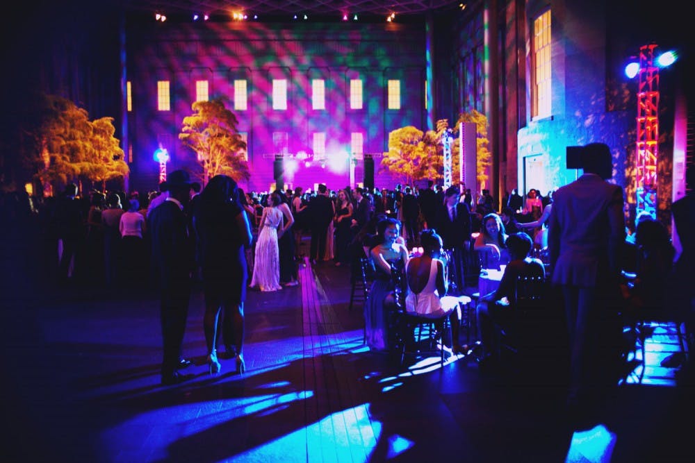 	Students mill about the Kogod courtyard chatting and eating food.