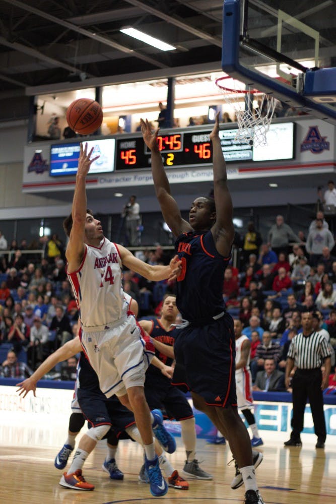 Senior Jesse Reed takes a shot over a Bucknell defender during a game last season. Photo credit: Bryan Park/ THE EAGLE&nbsp;