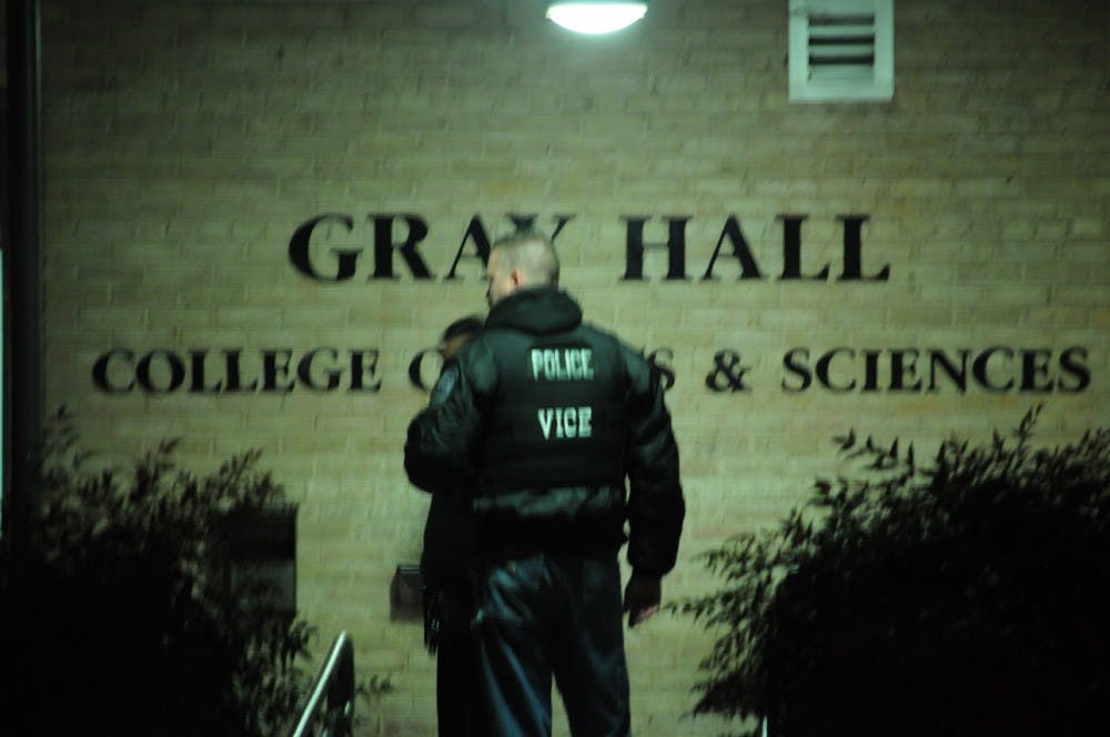 	Two police officers stand outside Gray Hall after D.C. Metropolitan Police Department searched the building. 