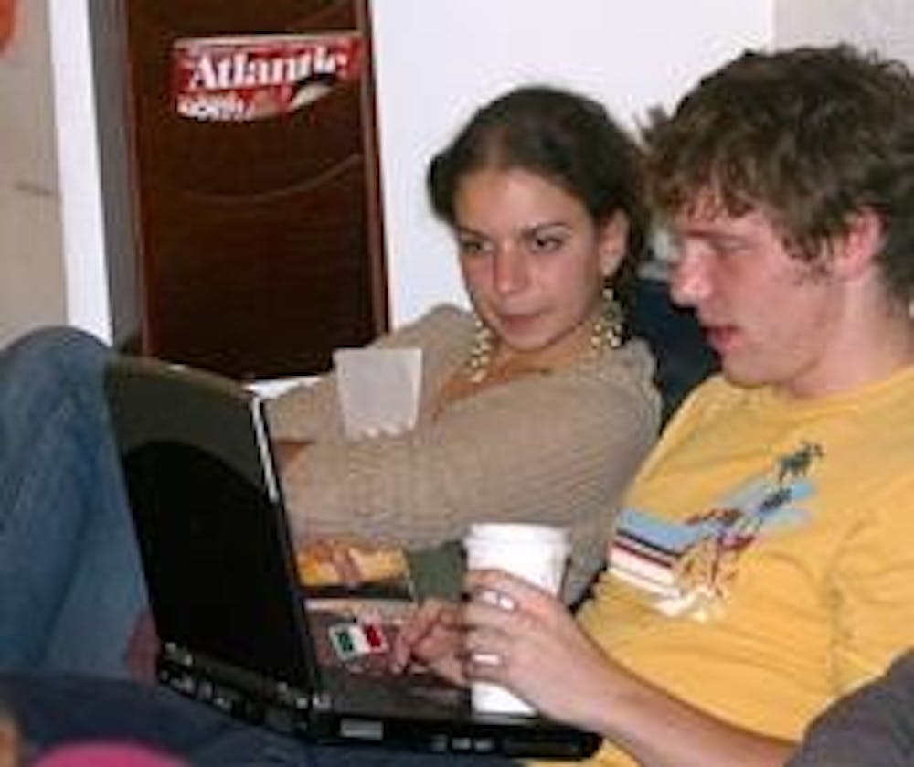 Juniors Kathy Rizzo and Charlie Caffrey study in the Davenport Lounge while drinking from new environmentally safe cups.