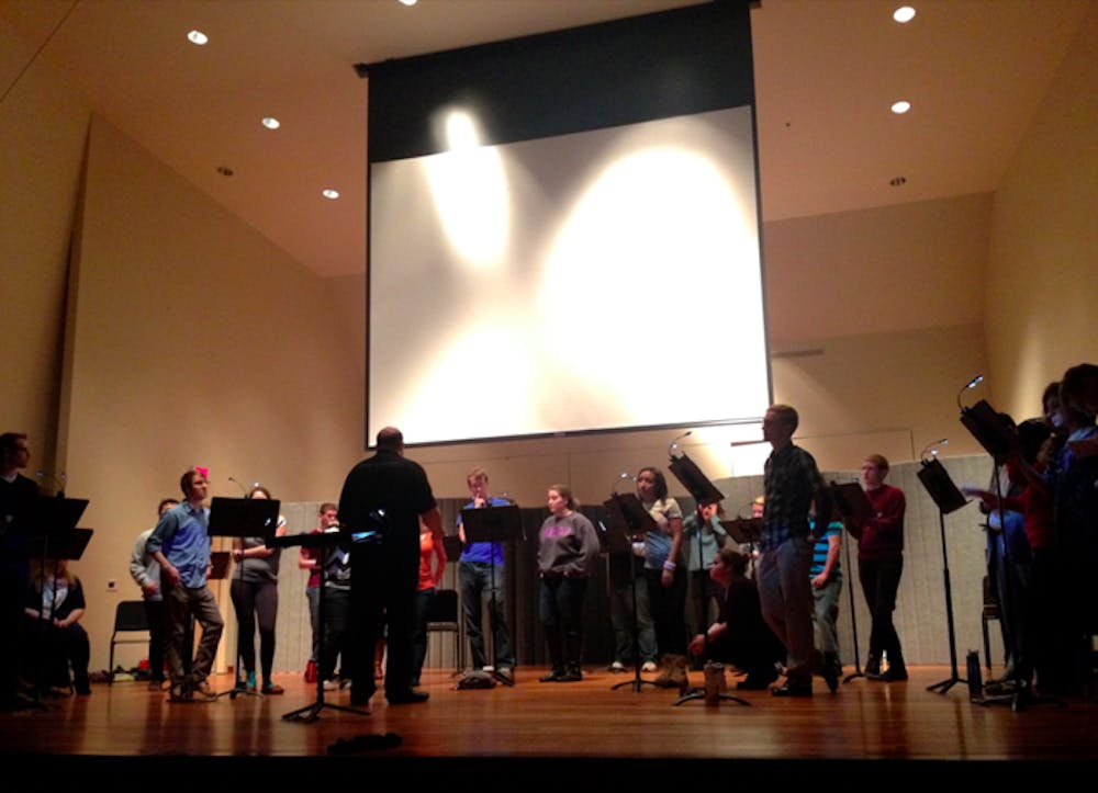 	Daniel Abraham conducts the AU Chamber Singers in “Parallel Universes.”