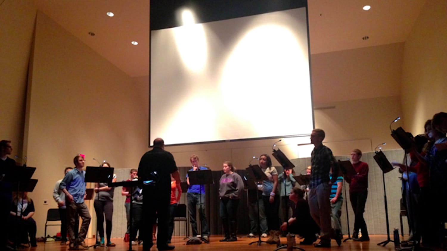 Daniel Abraham conducts the AU Chamber Singers in “Parallel Universes.”