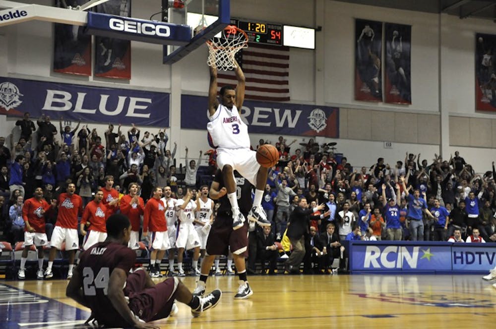 Junior guard Troy Brewer hangs on the rim during the second half of Wednesday\'s win against UMES.