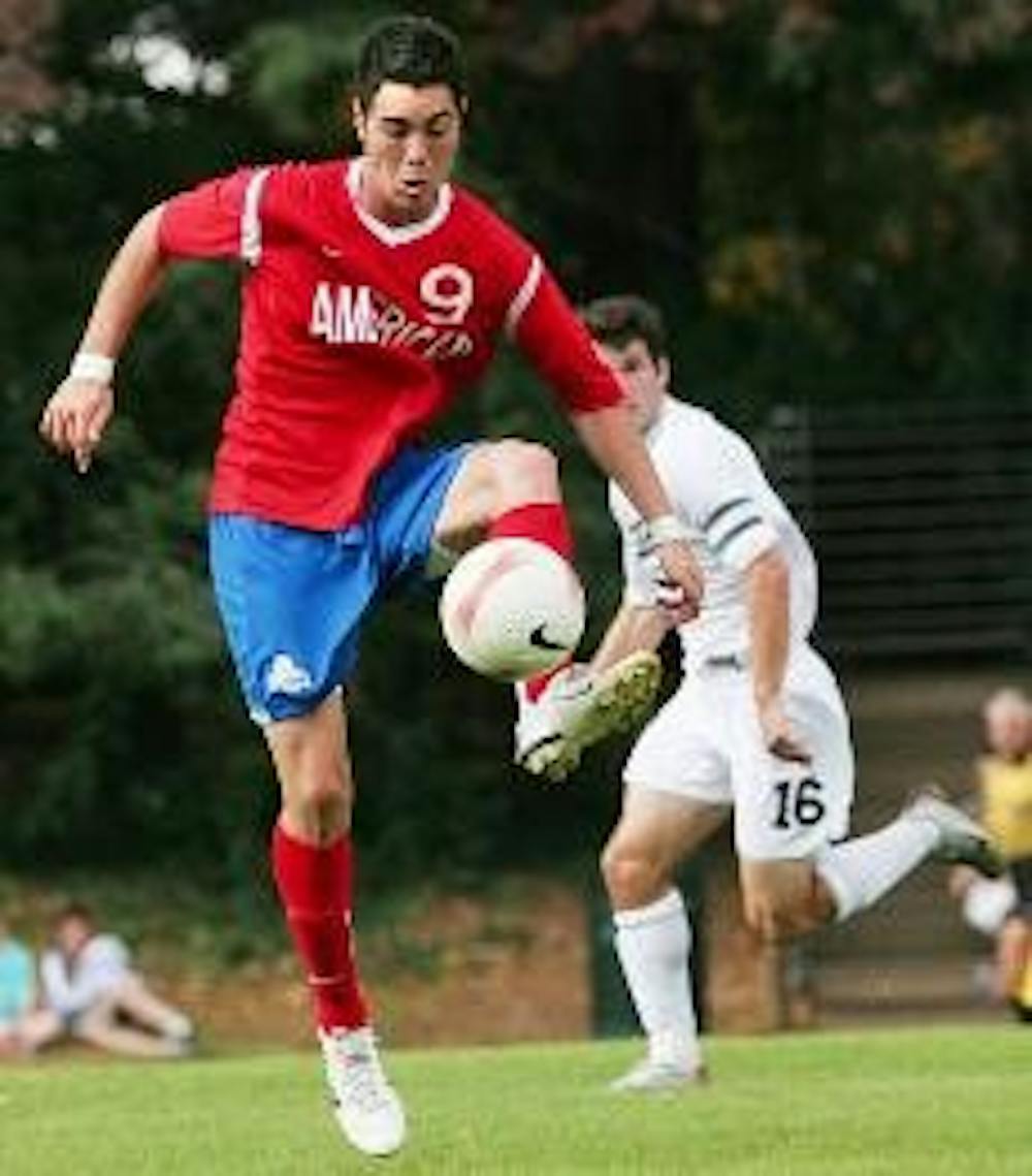 FANCY FOOTWORK - Junior forward Anthony Moy uses his dribbling skills to get around his opponents and pass the ball to a fellow Eagle. Moy later gained a penalty kick for the Eagles, which teammate Phil Purdy converted into a goal, giving AU a 1-0 lead in