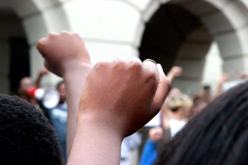 Students hold up fists at the #SolidarityWithOurSisters protest on Sept. 19.&nbsp;