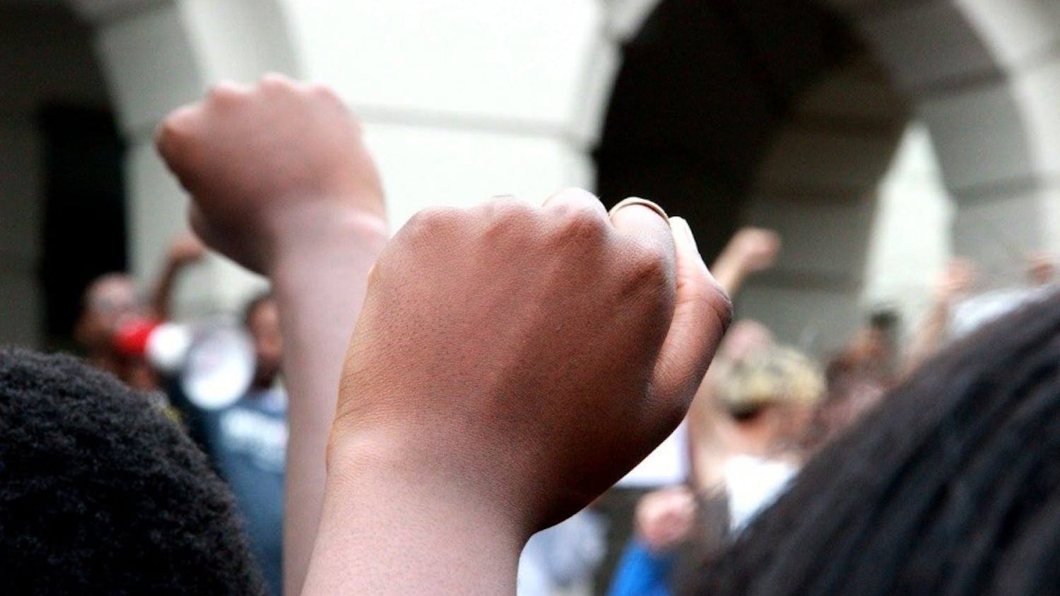 Students hold up fists at the #SolidarityWithOurSisters protest on Sept. 19.&nbsp;