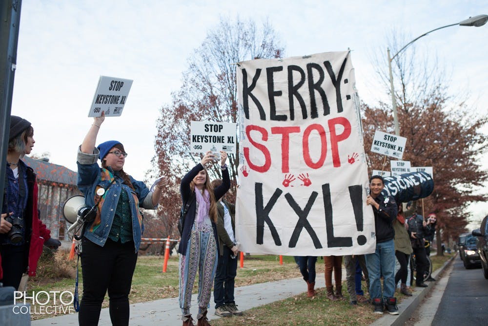 	AU students hold up a sign saying &#8220;Kerry: Stop K.XL&#8221; outside the School of International Service Building near the intersection between Nebraska Avenue and New Mexico Avenue.