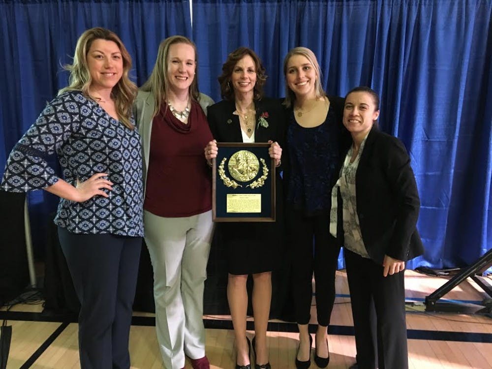 AU women's basketball head coach Megan Gebbia (center) with her plaque after being inducted into the Frederick County Sports Hall of Fame&nbsp;