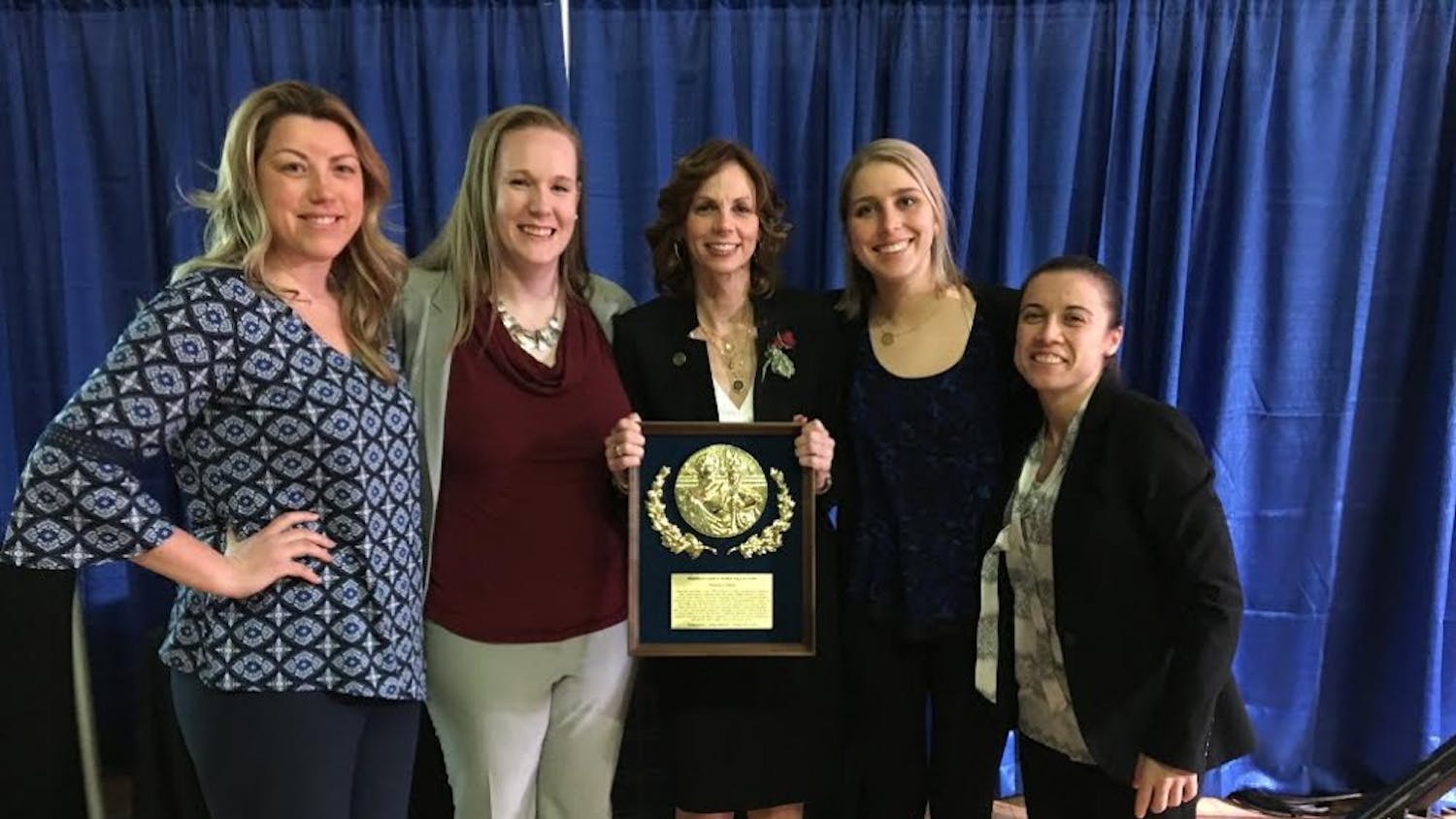 AU women's basketball head coach Megan Gebbia (center) with her plaque after being inducted into the Frederick County Sports Hall of Fame&nbsp;