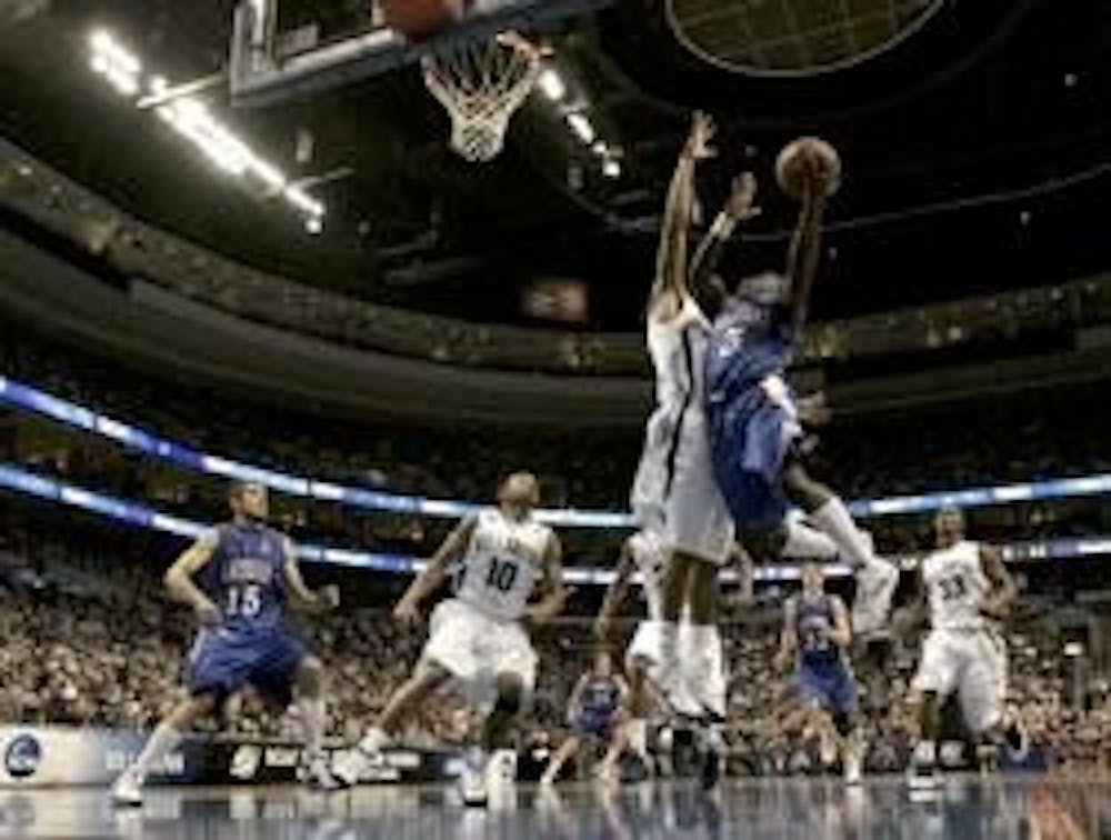 JUMP SHOT - American's Derrick Mercer drives on Villanova's Reggie Redding during first half action at the Wachovia Center in Philadelphia.