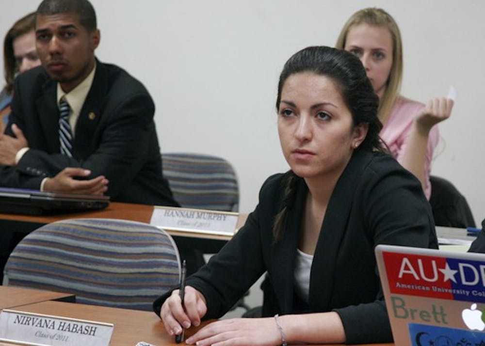 ROUGH DAY â€” Class of 2011 Senator Nirvana Habash, right, and Class of 2013 President Jose Morales, left, listen to proceedings at Sundayâ€™s Undergraduate Senate meeting. The Senate voted to certify the results of the election, despite calls to nullify the presidential race. 
