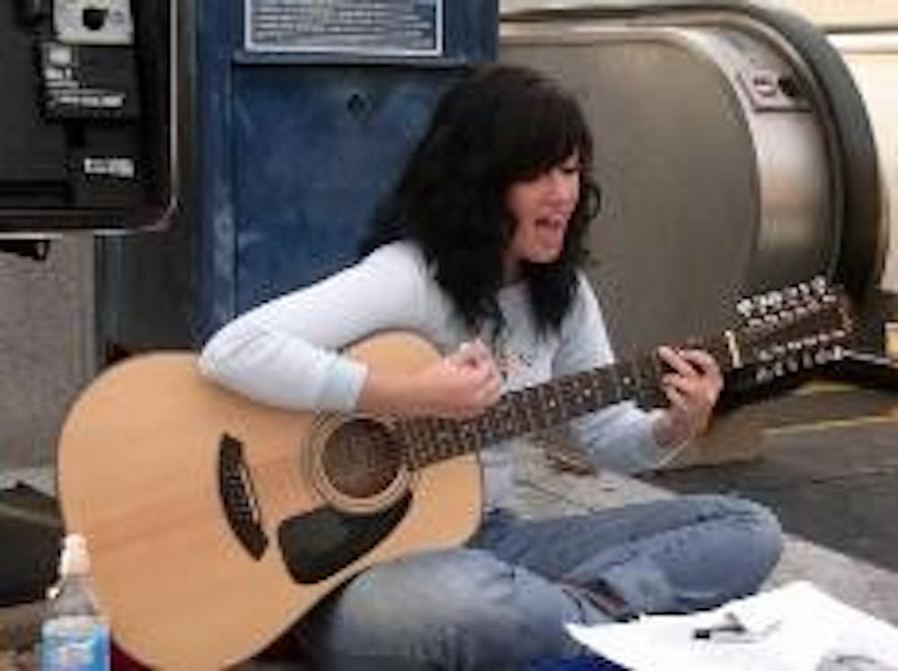 STREET CRED - Freshman Kristen Parotta performs her version of Bob Dylan's "Mr. Tambourine Man" at the Tenleytown Metro station. Parotta is one of several performers taking music to the streets of D.C. She embraces street music as a professional and perso