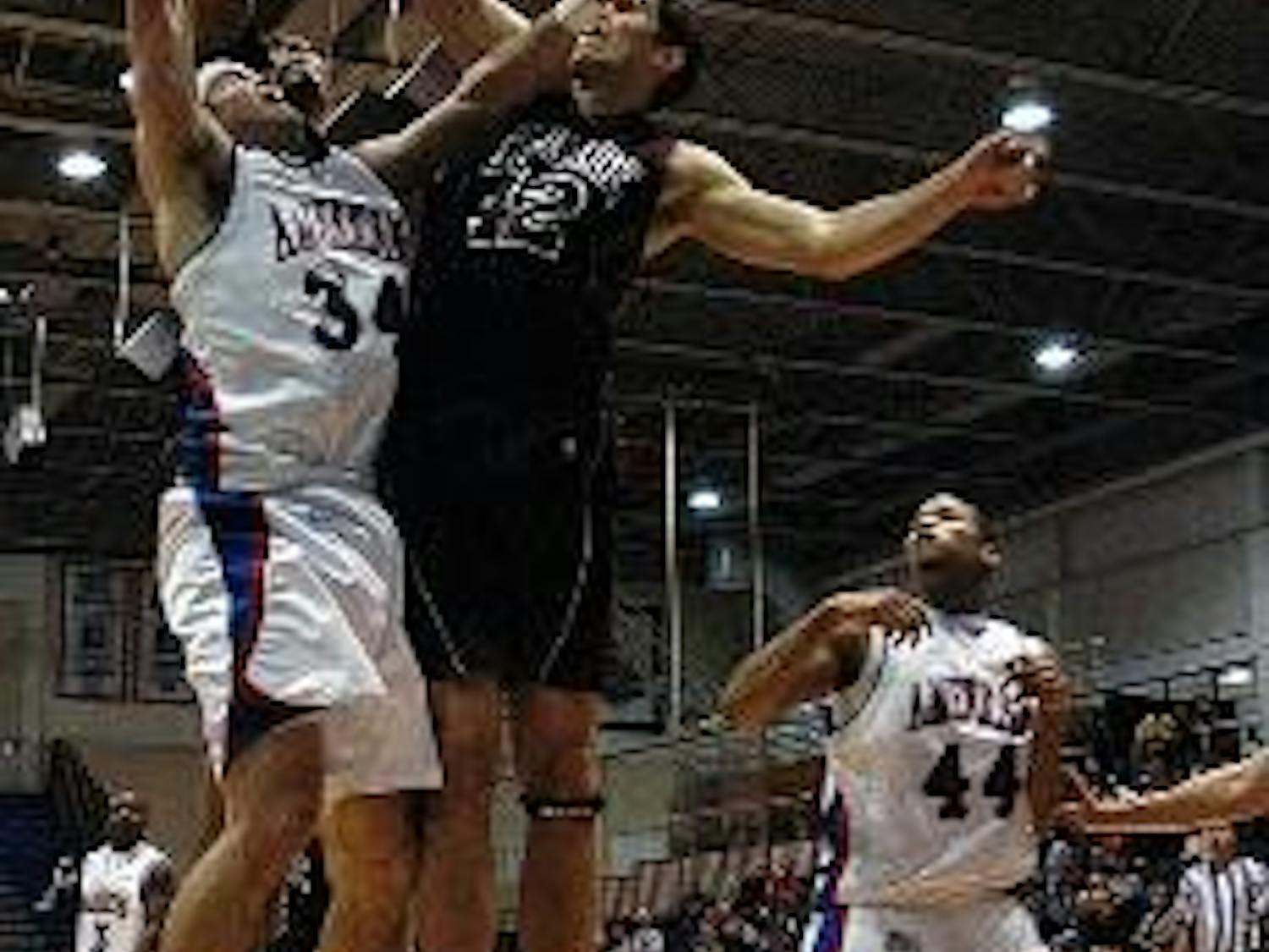 TRIPLE JUMP- Senior Travis Lay soars above two defenders as the Eagles seize a second straight Patriot League victory. AU is now tied with Bucknell University for second place in the league.