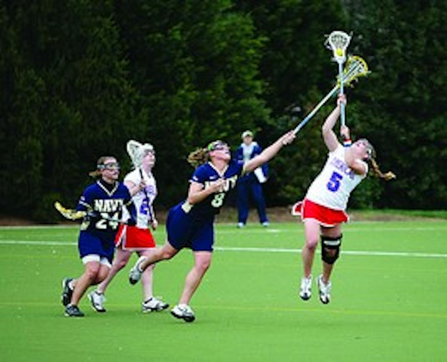 REACHING HIGH- Senior midfielder Leslie Fischer leaps up to steal the ball from her Navy opponent.