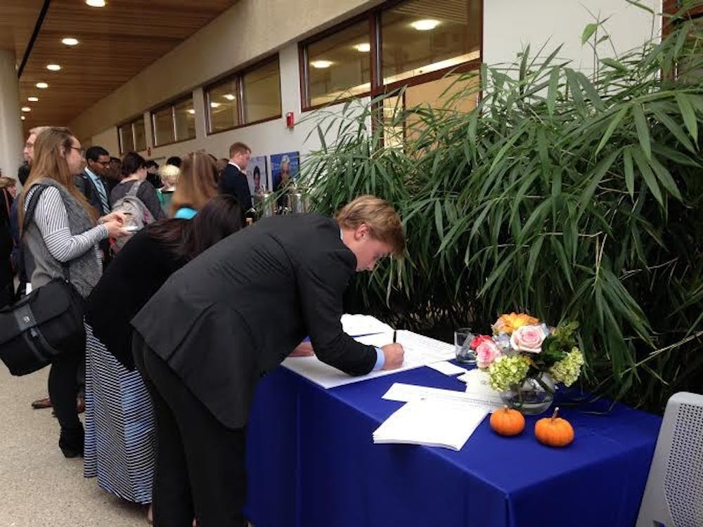 Cooper Lohr, a junior in the School of Public Affairs, signs a poster to be sent to&nbsp;Shlonsky's parents. Lohr was one of Shlonsky's&nbsp;'littles' in his fraternity.&nbsp;