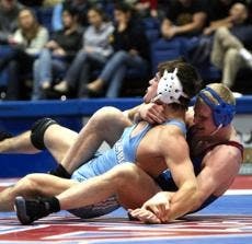 PINNING THE BOOKS - Mike Gannon battles with an opponent last year during a home match. Gannon was one of two Academic All-Americans on the team. He is joined by senior Andrew Silber.