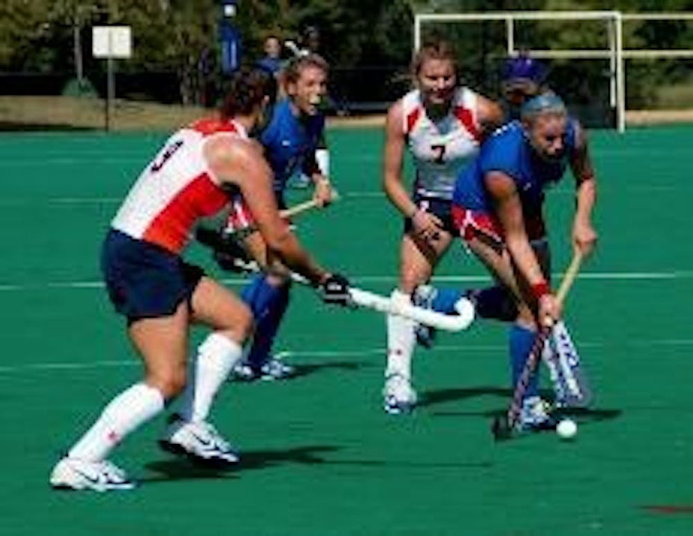 BATTLE FOR THE BALL- The Eagles work together to hold off the Syracuse University Orangewomen. Although the Eagles outshot their opponent 19-7, in the end, they were unable to gain the win. AU field hockey is currently 9-3 and looks to improve the record 