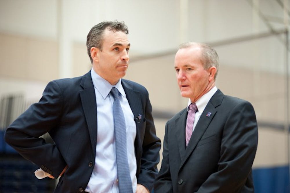 	Mike Brennan (left), the new head coach of men&#8217;s basketball, talks with Athletic Director Billy Walker (right).