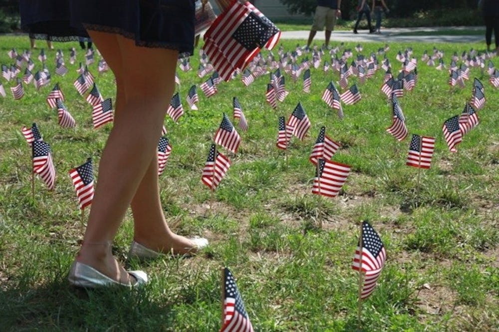 An AU student places flags on the quad to commemorate the 10th anniversary of Sept. 11.