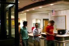 Students walk past the Anderson-Centennial front desk, where a keg was seized Tuesday. 