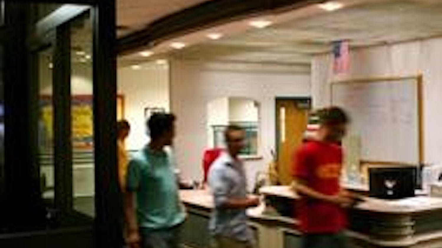 Students walk past the Anderson-Centennial front desk, where a keg was seized Tuesday. 