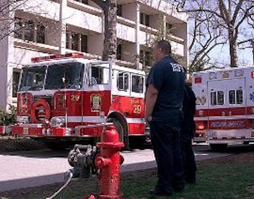 FALSE ALARM - A member of the D.C. Fire Department looks on as firefighters respond to a fire alarm in the Ward Circle Building Tuesday. An air-handling motor burned out and filled the building\'s terrace level with smoke. Public Safety let people re-enter