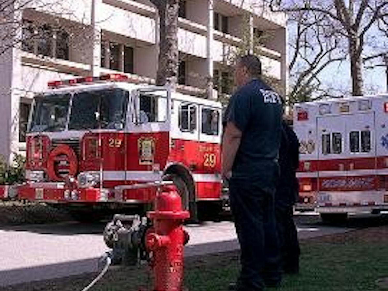 FALSE ALARM - A member of the D.C. Fire Department looks on as firefighters respond to a fire alarm in the Ward Circle Building Tuesday. An air-handling motor burned out and filled the building\'s terrace level with smoke. Public Safety let people re-enter