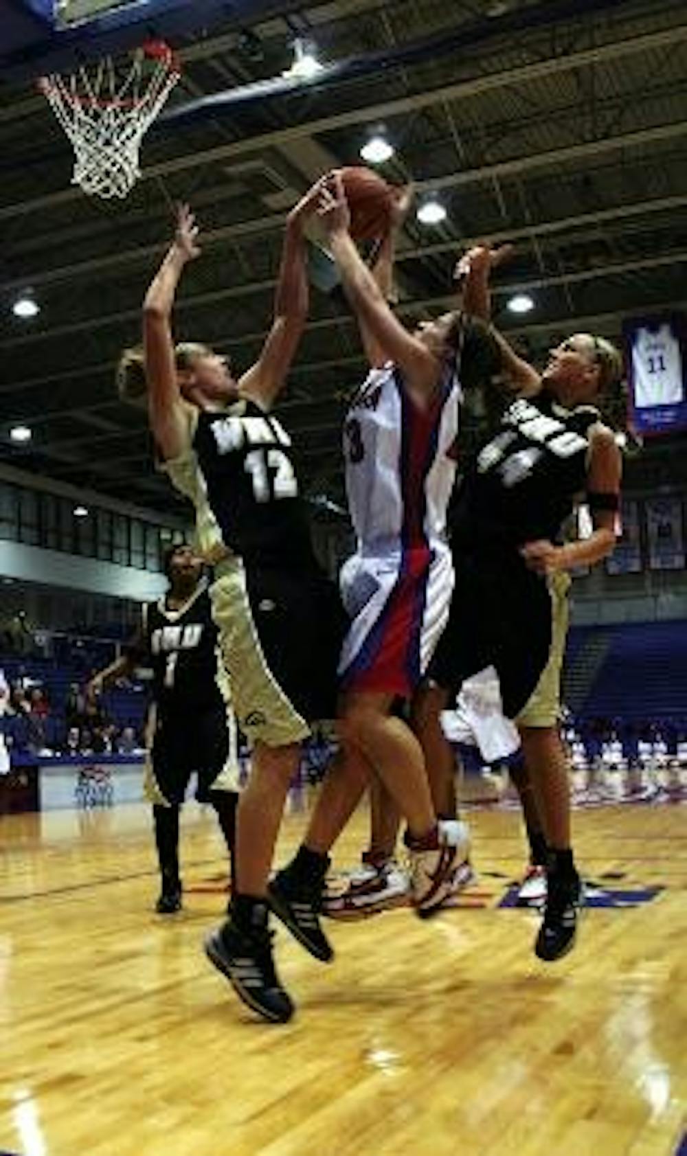 EAGLES SOAR - Senior Maggie Smith-Davidson fights two Western Michigan University players to make a shot. Strong gameplay by the Eagles allowed them to defeat the Broncos 65-61.