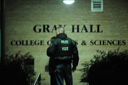 Police officer stands in front of Gray Hall during 2013 gun scare. 