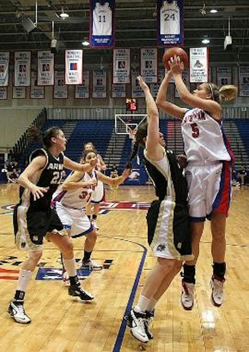 JUMP SHOT- Freshman Michelle Kirk jumps to take a shot as her opponent attempts to block her. It did not help the Eagles pull through, though, as they continued their eight-game losing streak yesterday.