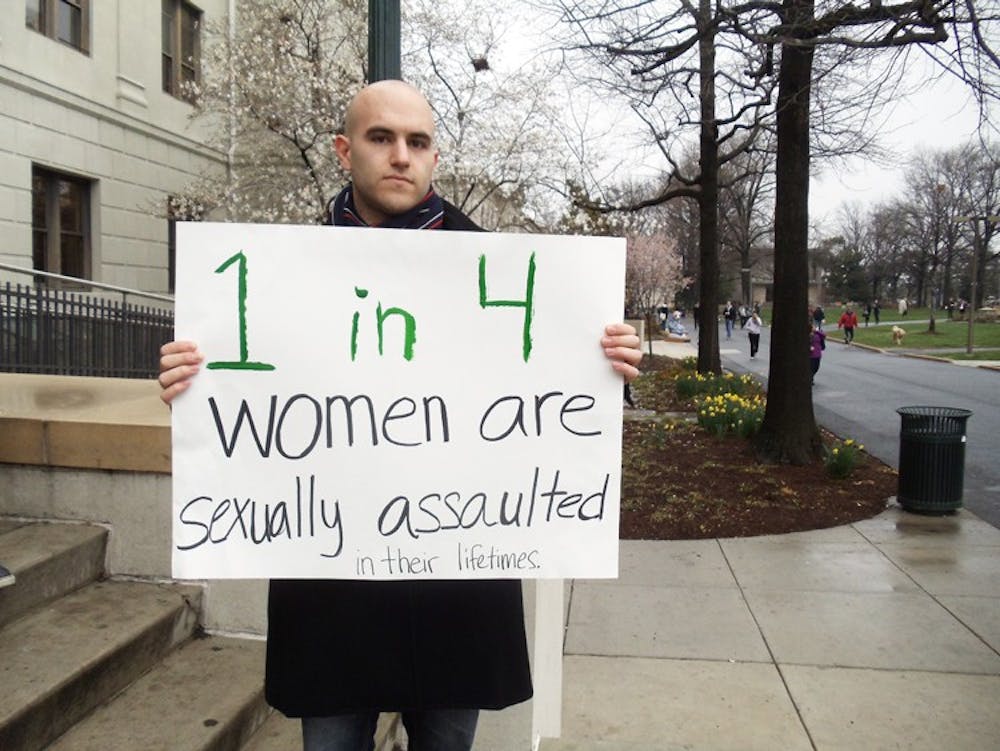 Robert Lutz holds a sign during Thursday\'s protest.