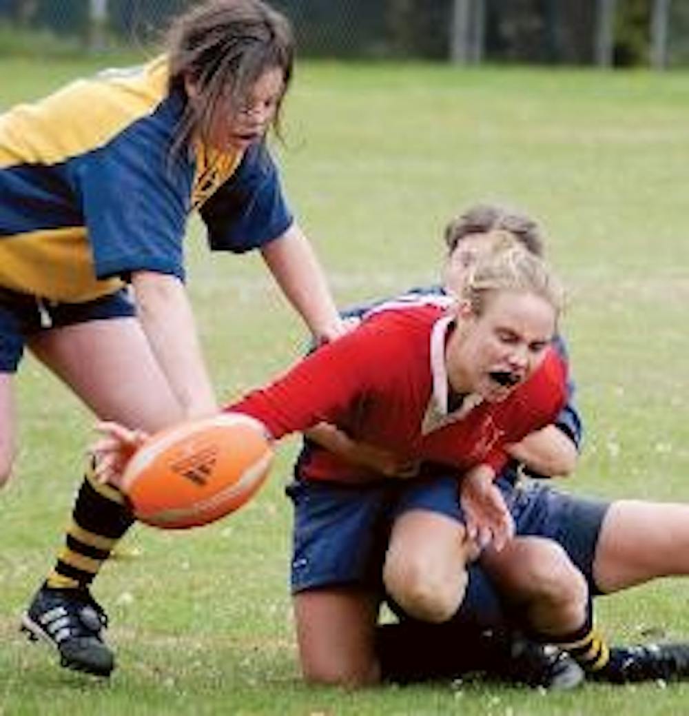 TOUGH TACKLE - Senior Joanna Ison gets tackled while running the ball at the only home game for the women's rugby team. The women came out on top of their local rivals George Washington with a score of 48-29.