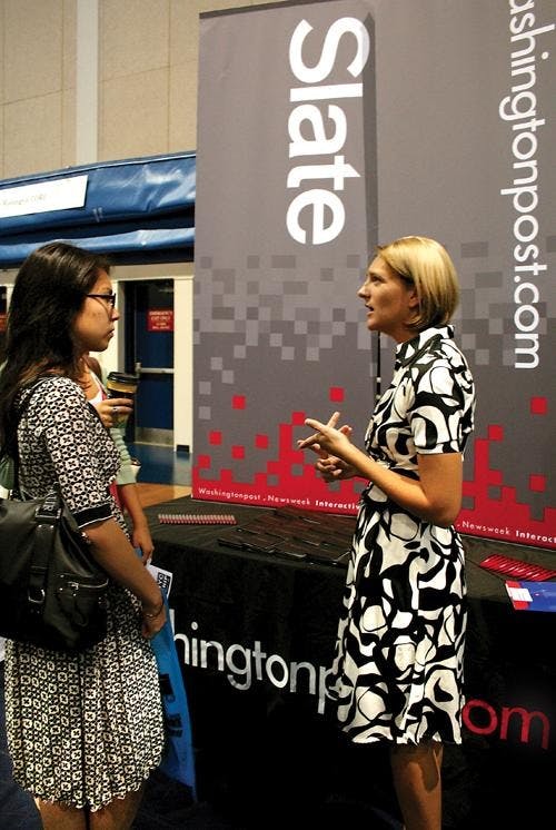 JOB HUNTING - A student speaks with a representative of washingtonpost.com at the Job and Internship Fair, which the AU Career Center sponsored and held Thursday in Bender Arena. More than 100 companies tabled at the event, attracting and recruiting peopl