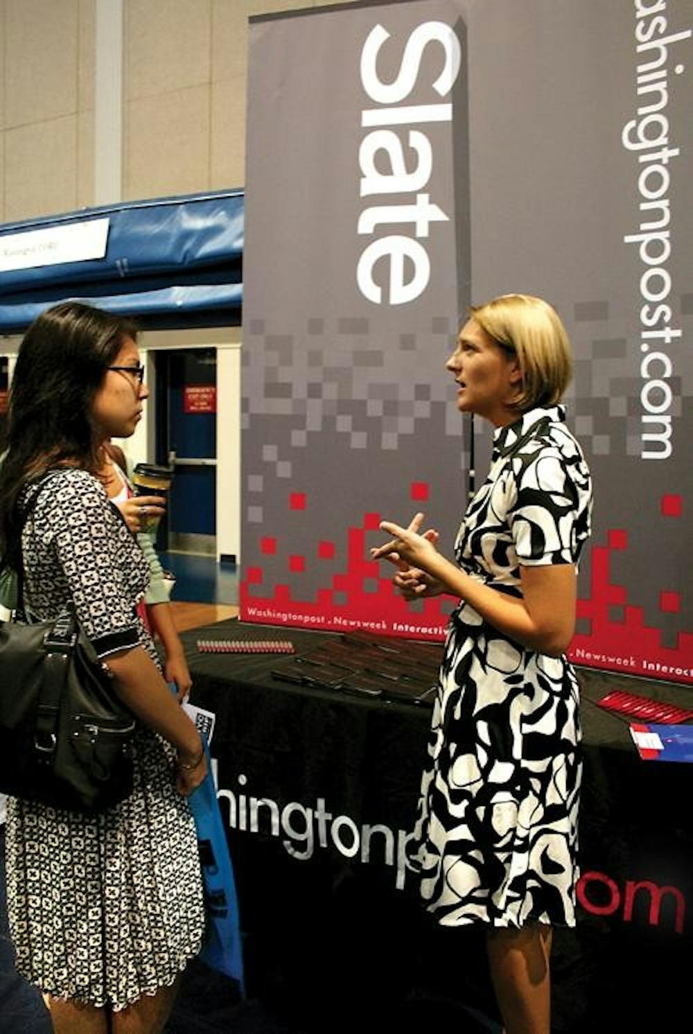 JOB HUNTING - A student speaks with a representative of washingtonpost.com at the Job and Internship Fair, which the AU Career Center sponsored and held Thursday in Bender Arena. More than 100 companies tabled at the event, attracting and recruiting peopl