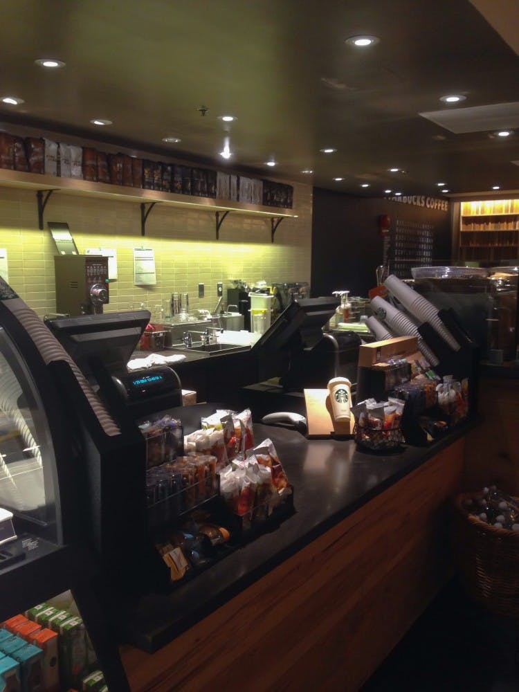 	The front counter of the store is located on the left side of the store, featuring similar qualities to other Starbucks locations.