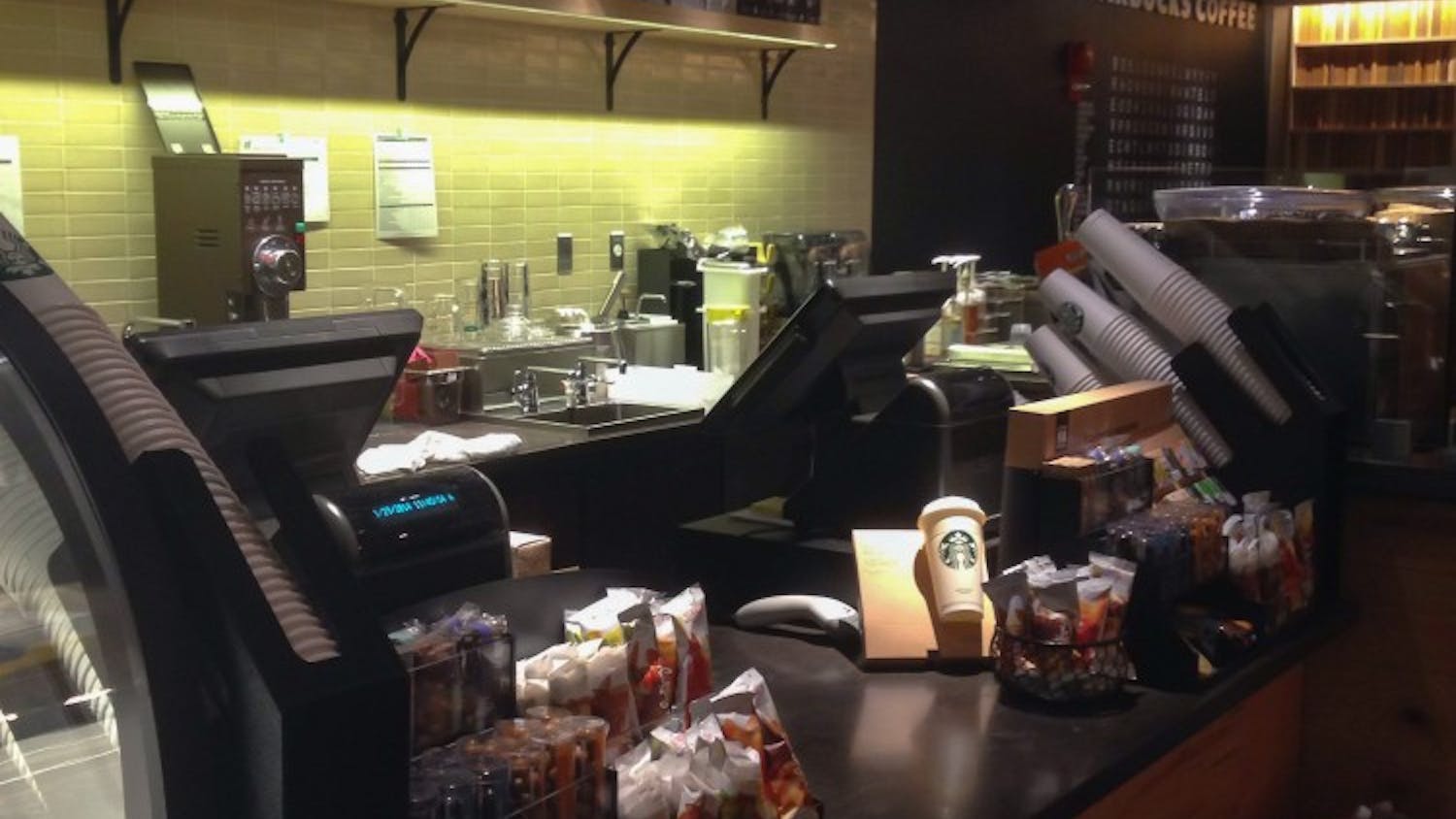 	The front counter of the store is located on the left side of the store, featuring similar qualities to other Starbucks locations.