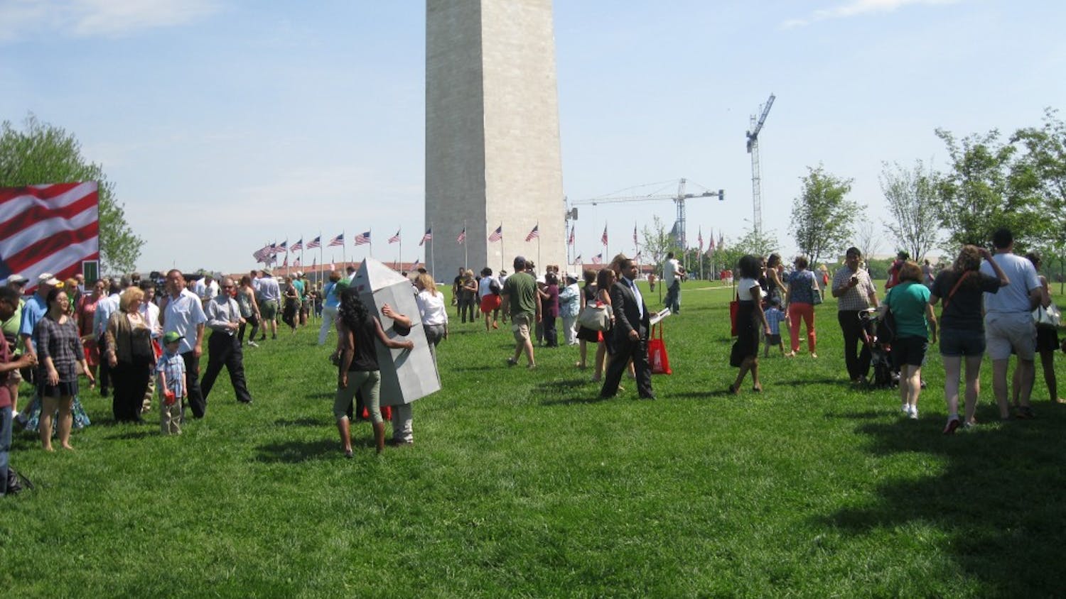 	Spectators pose with a live-action version of the Washington Monument.