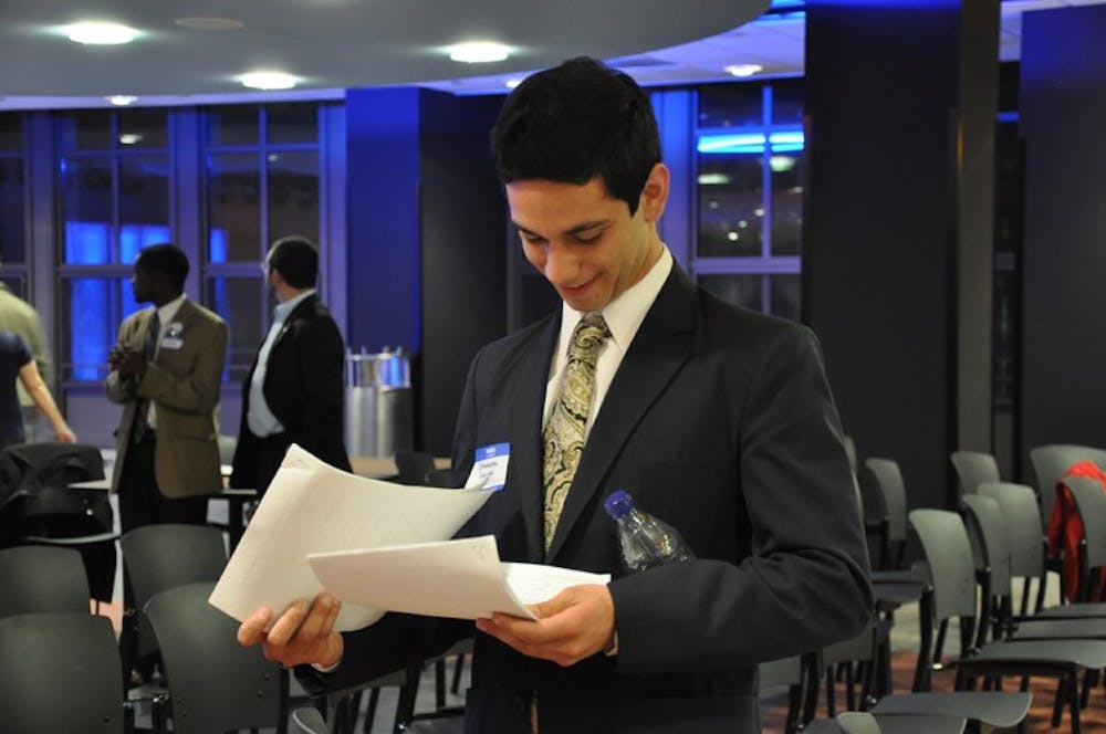 CALLED TO COURT â€” SG presidential candidate Ibraheem Samirah looks over his newly-acquired court summons Sunday night. Samirah was handed the papers during a meet-and-greet event after ATVâ€™s SG Presidential Debate. His former roommates are suing him for allegedly failing to pay rent since November.