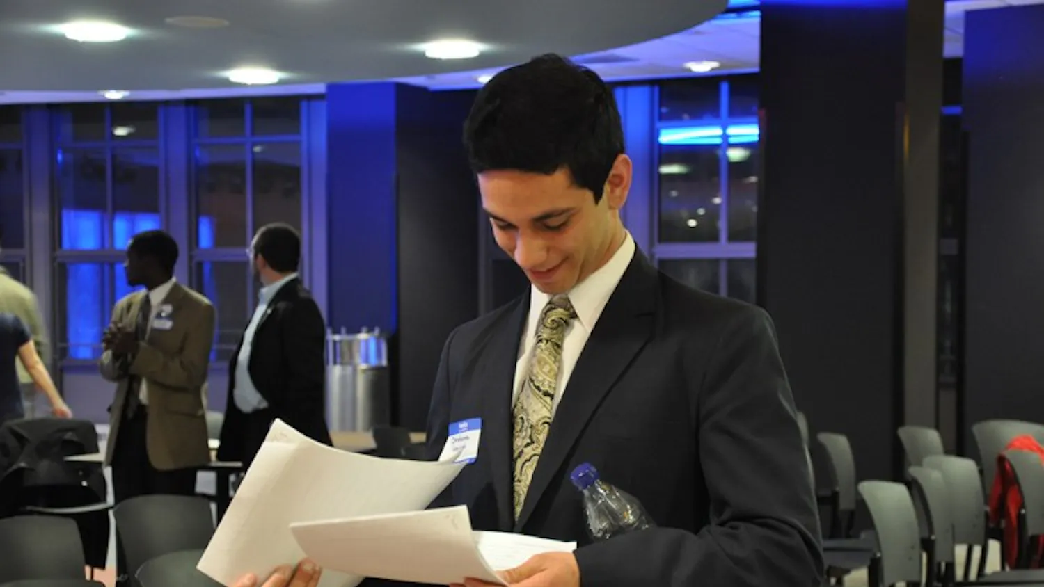 CALLED TO COURT — SG presidential candidate Ibraheem Samirah looks over his newly-acquired court summons Sunday night. Samirah was handed the papers during a meet-and-greet event after ATV’s SG Presidential Debate. His former roommates are suing him for allegedly failing to pay rent since November.