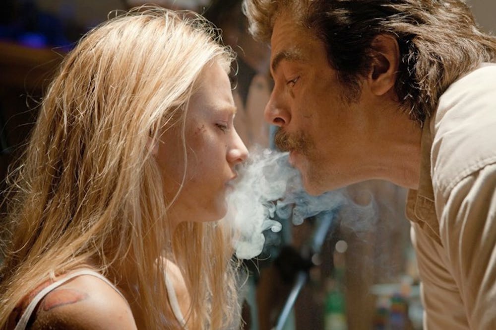 Lado (Benicio del Toro) threatens O (Blake Lively) in an attempt to lure in her drug-dealing lovers.